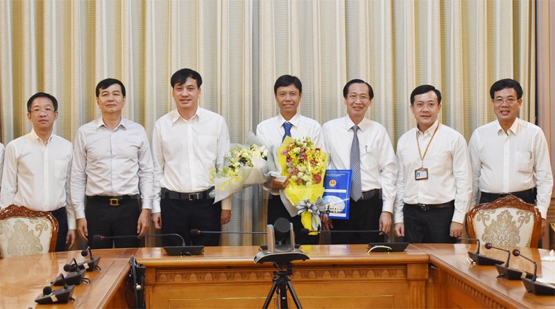 Phó Chủ tịch Thường trực UBND TPHCM Lê Thanh Liêm tặng hoa chúc mừng đồng chí Nguyễn Bá Thành. 