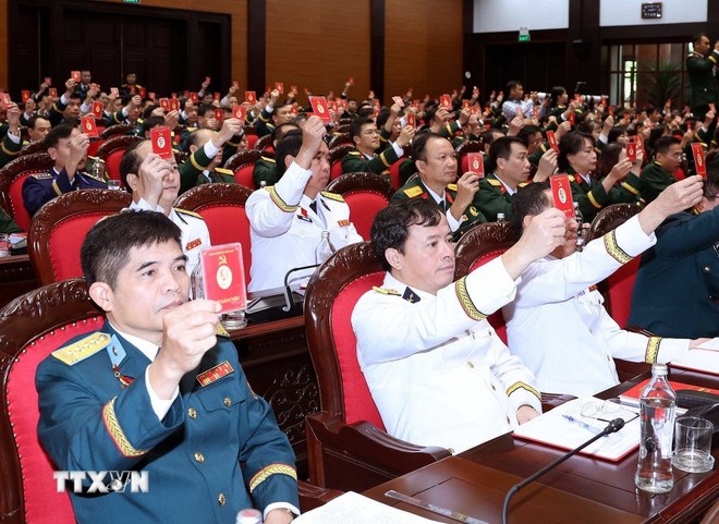 Các đại biểu biểu quyết thông qua Nghị quyết Đại hội. (Ảnh: TTXVN)