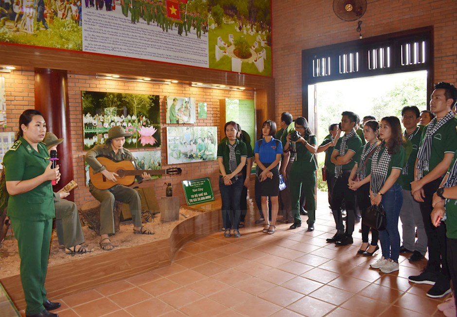 Các thành viên trong đoàn nghe thuyết trình về cuộc chiến tranh biên giới Tây Nam tại Khu tưởng niệm Liệt sĩ Thanh niên xung phong