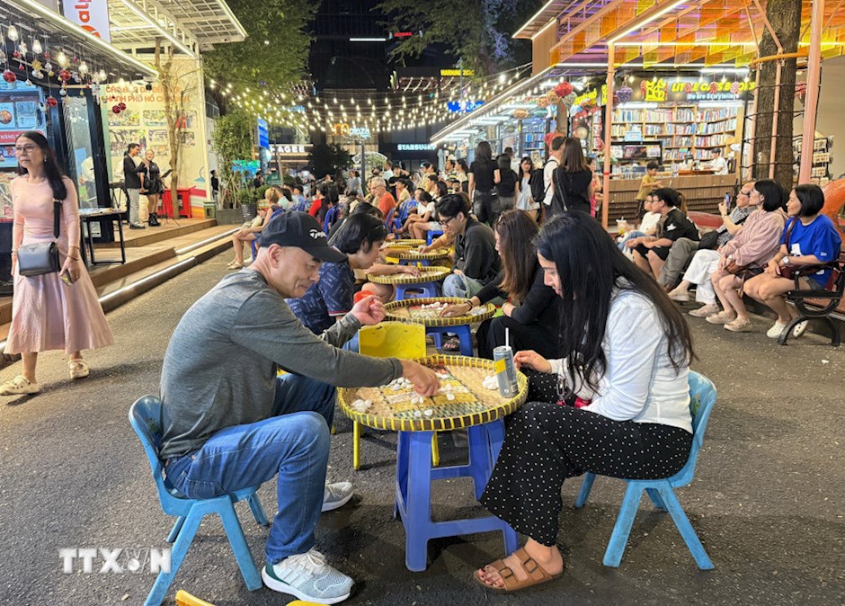 Tr&ograve; chơi &ocirc; ăn quan được nhiều người d&acirc;n, du kh&aacute;ch tham gia.(Ảnh: TTXVN)