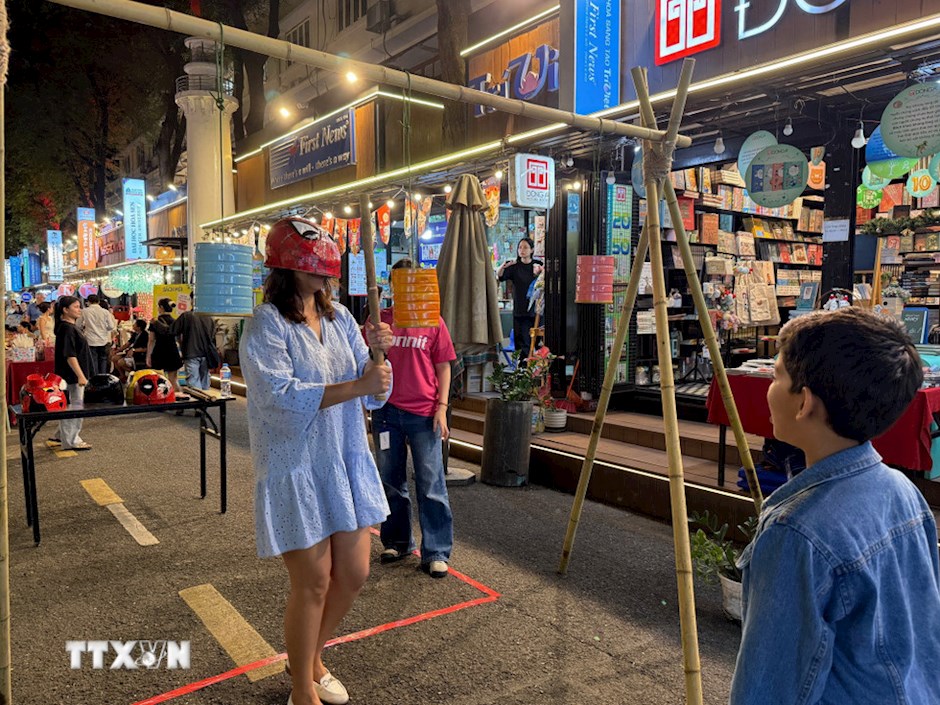 C&aacute;c tr&ograve; chơi d&acirc;n gian c&ograve;n thu h&uacute;t cả du kh&aacute;ch nước ngo&agrave;i tham gia. (Ảnh: TTXVN)