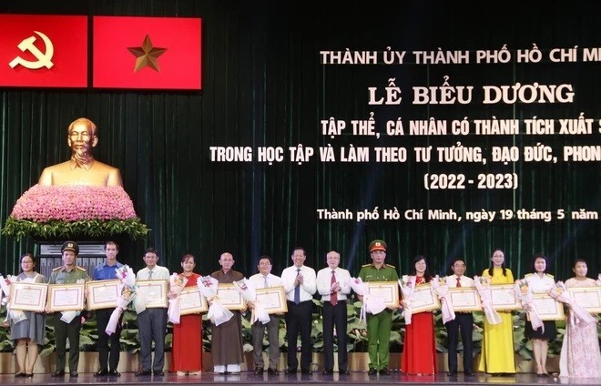 Các đồng chí lãnh đạo Thành phố Hồ Chí Minh trao bằng khen cho các cá nhân, tập thể có thành tích xuất sắc trong học tập và làm theo tư tưởng, đạo đức, phong cách Hồ Chí Minh năm 2022 - 2023. (Ảnh: TTXVN)
