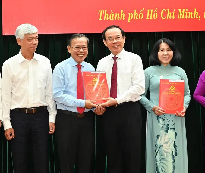 Đồng chí Nguyễn Văn Nên trao quyết định nghỉ hưu trước tuổi cho đồng chí Nguyễn Hữu Hiệp. (Ảnh: SGGP)