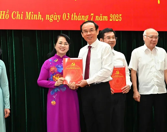 Đồng chí Nguyễn Văn Nên trao quyết định nghỉ hưu trước tuổi cho đồng chí Trần Kim Yến. (Ảnh: SGGP)