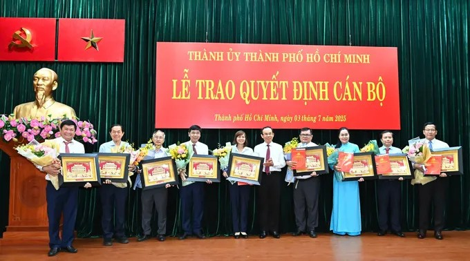 Bí thư Thành ủy TPHCM Nguyễn Văn Nên tặng hoa và quà lưu niệm đến các đồng chí nghỉ hưu trước tuổi. (Ảnh: SGGP)