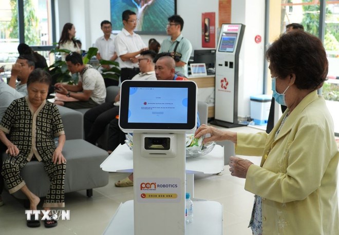 Người dân trải nghiệm các robot phục vụ. (Ảnh: TTXVN)