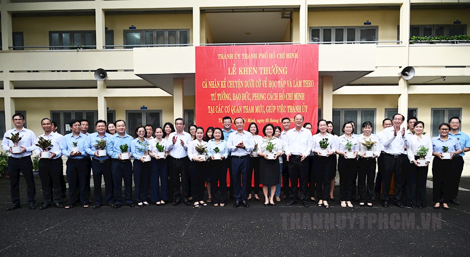 Đồng chí Nguyễn Văn Nên và đồng chí Nguyễn Hồ Hải cung các đồng chí Ủy viên Ban Thường vụ Thành ủy chụp hình lưu niệm cùng các cá nhân tham gia dưới cờ về học tập và làm theo tư tưởng, đạo đức, phong cách Hồ Chí Minh tại các cơ quan tham mưu, giúp việc Thành ủy. (ảnh: Việt Phan)