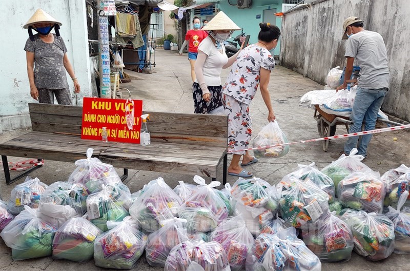 Hỗ trợ quà cho người dân trong khu vực cách ly. (Ảnh: Hồ Trung)