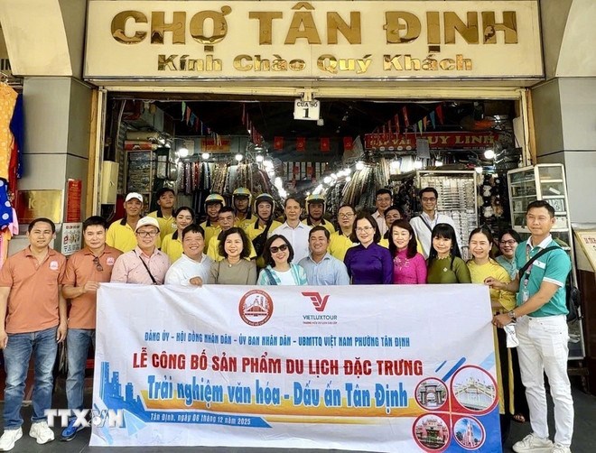 Đoàn du khách tham gia tour “Trải nghiệm văn hóa – Dấu ấn Tân Định” tại Phường Tân Định. (Ảnh: TTXVN)