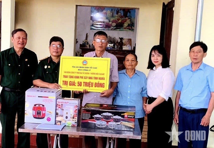 Lãnh đạo Hội Nạn nhân chất độc da cam/dioxin tỉnh Bắc Ninh và nhà tài trợ trao tiền hỗ trợ xây dựng nhà tặng nạn nhân ở phường Chũ, tỉnh Bắc Ninh. (Ảnh: QDND.vn)