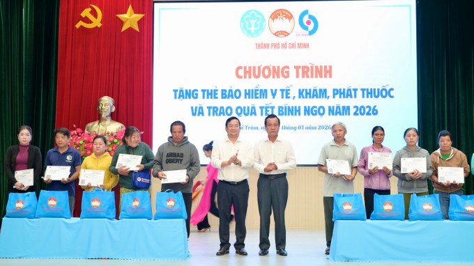 Người dân xã Hồ Tràm nhận BHYT và quà. (Ảnh: SGGP)