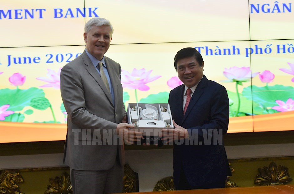 Chủ tịch UBND TPHCM Nguyễn Thành Phong trao quà lưu niệm cho Giám đốc Ngân hàng phát triển Châu Á (ADB) tại Việt Nam Eric Sidgwick