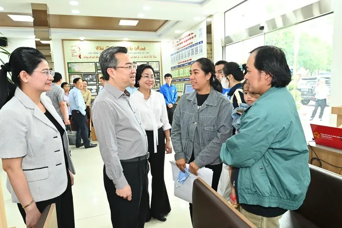 Đồng chí Nguyễn Thanh Nghị trò chuyện cùng người dân đến làm thủ tục hành chính tại Trung tâm phục vụ Hành chính công phường Bình Thới. (Ảnh: SGGP)