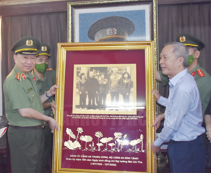 Đồng chí Tô Lâm tặng quà lưu niệm cho đại diện gia đình đồng chí Mai Chí Thọ.