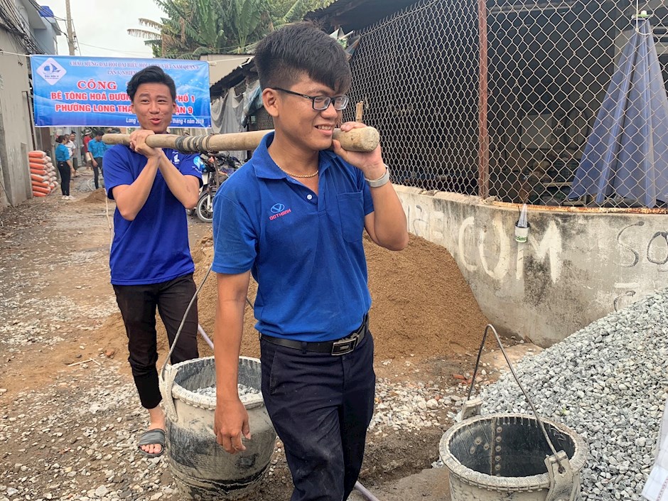 Anh Thi Văn Ngọc Tuấn (bìa phải) tham gia thực hiện bê tông hóa tuyến đường số 17, khu phố 1, phường Long Thạnh Mỹ năm 2019