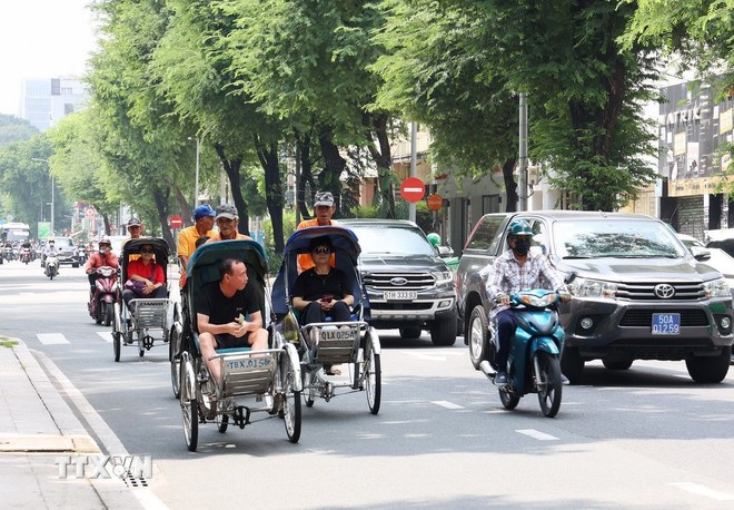 Kh&aacute;ch quốc tế tham quan trung t&acirc;m Th&agrave;nh phố Hồ Ch&iacute; Minh. (Ảnh: TTXVN)