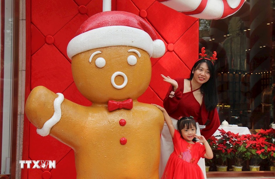 Nhiều gia đ&igrave;nh tại TP. Hồ Ch&iacute; Minh lựa chọn trang phục m&agrave;u đỏ rực rỡ, g&oacute;p phần l&agrave;m nổi bật kh&ocirc;ng kh&iacute; Gi&aacute;ng sinh. (Ảnh: TTXVN)