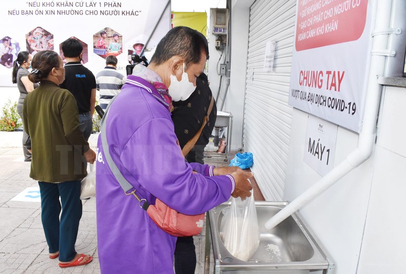 Người nghèo, người lao động tự do lấy gạo tại “ATM gạo” miễn phí ở số 204, đường Vườn Lài, quận Tân Phú, TPHCM. 