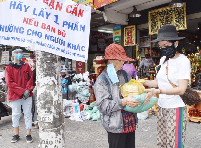 Chị Nguyễn Thị Chu My, chủ cửa hàng kinh doanh Hoàng Long, số 165 - 167, đường Trường Chinh, Phường 12, quận Tân Bình trao tặng quà hỗ trợ người khó khăn. 