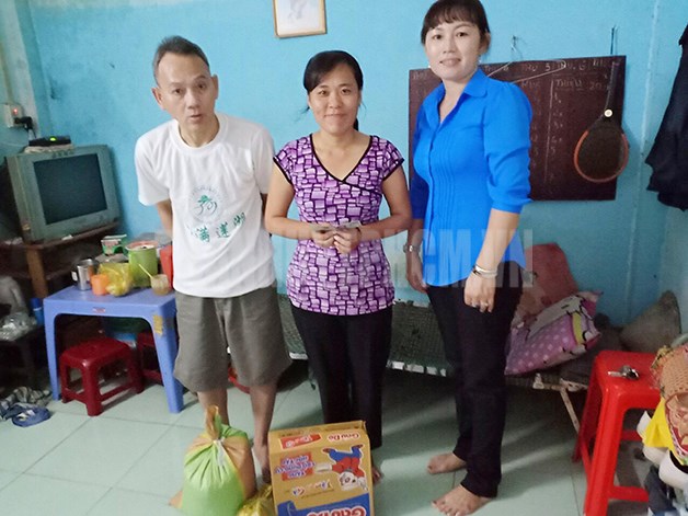 Chị Nguyễn Thị Minh Lâm (phải) tặng quà cho gia đình khó khăn.