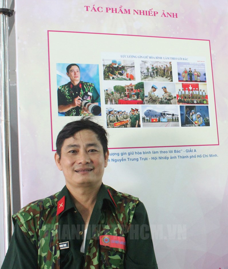 Nghệ sĩ nhiếp ảnh - chiến sĩ Nguyễn Trung Trực bên bộ ảnh “Lực lượng gìn giữ hòa bình Việt Nam làm theo lời Bác”.