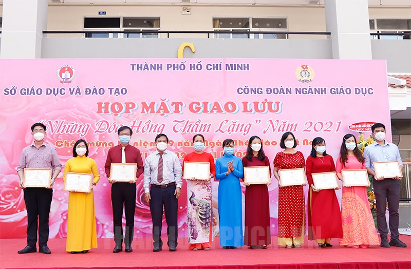 Ông Nguyễn Huỳnh Long - Phó Bí thư Thường trực Đảng ủy Sở Giáo dục và Đào tạo Thành phố (hàng thứ 4 từ trái qua) và bà Huỳnh Thị Ngọc Liên (áo dài xanh) - Ủy viên Ban Thường vụ, Trưởng ban Nữ công Liên đoàn Lao động Thành phố trao thưởng đến các thầy cô giáo.