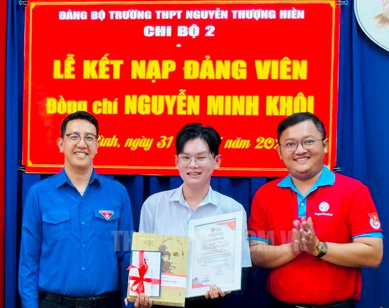 Đồng chí Phan Lê Huy Hoàng, Bí thư Quận Đoàn trao tặng quà chúc mừng cho đảng viên tuổi 18 Nguyễn Minh Khôi