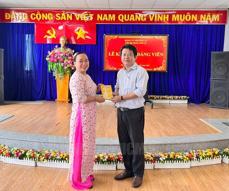 Đồng chí Phạm Duy Vinh, Phó Bí thư Thường trực Đảng ủy Phường 14 chúc mừng đảng viên mới Đoàn Thị Thu Trang
