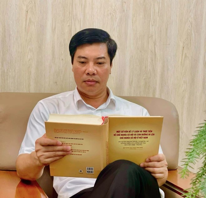 Ông Nguyễn Minh Thắng, Ủy viên Ban Thường vụ, Trưởng ban Tuyên giáo Thành ủy Chí Linh đang xem sách của Tổng Bí thư Nguyễn Phú Trọng. (Ảnh: TTXVN)