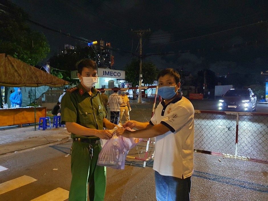 Chủ tịch Ủy ban MTTQ Việt Nam phường Linh Tây Nguyễn Vũ Bảo (phải) gửi các suất ăn đêm đến lực lượng cán bộ chiến sĩ làm nhiệm vụ tại chốt giáp ranh phường Linh Tây và phường An Bình