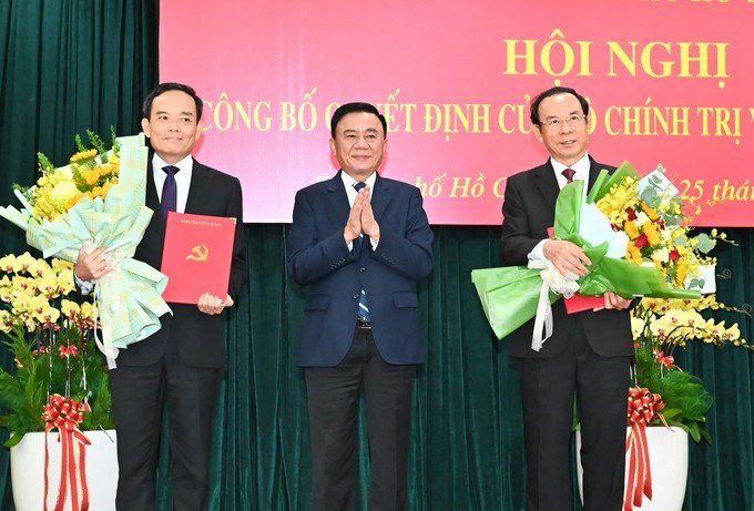 Đồng chí Trần Cẩm Tú trao quyết định và tặng hoa chúc mừng đồng chí Nguyễn Văn Nên và đồng chí Trần Lưu Quang. (Ảnh: SGGP)