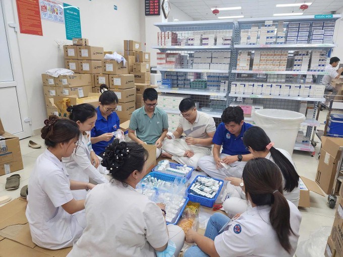 Các y, bác sĩ Bệnh viện Hùng Vương đóng gói túi thuốc gia đình hỗ trợ người dân vùng lũ