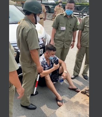 Lê Chí Thành ngồi trước đầu xe trong lúc bị CSGT xử phạt. (Ảnh: Plo.vn)