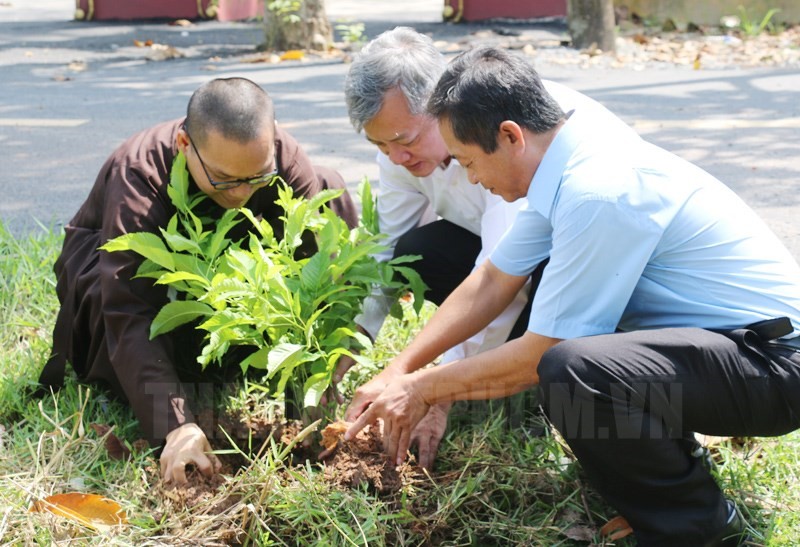 Đồng chí Dương Văn Duyên (giữa), Trưởng Ban Dân vận Huyện ủy, Chủ tịch Ủy ban MTTQ Việt Nam huyện Củ Chi và Đại đức Thích Thiện Tâm trồng hoa chuông vàng trên tuyến đường Nguyễn Thị Đây, ấp Trung Hiệp Thạnh, xã Trung Lập Thượng huyện Củ Chi.