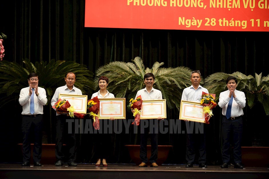 Chủ tịch UBND TP Nguyễn Thành Phong và Thứ trưởng Bộ Nông nghiệp - Phát triển nông thôn Lê Quốc Doanh trao Bằng khen của Thủ tướng Chính phủ cho các tập thể, cá nhân. (ảnh: Đan Như)