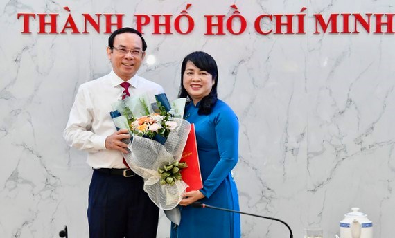 Bí thư Thành ủy TPHCM Nguyễn Văn Nên trao quyết định và tặng hoa chúc mừng đồng chí Trần Kim Yến. (Ảnh: SGGP)