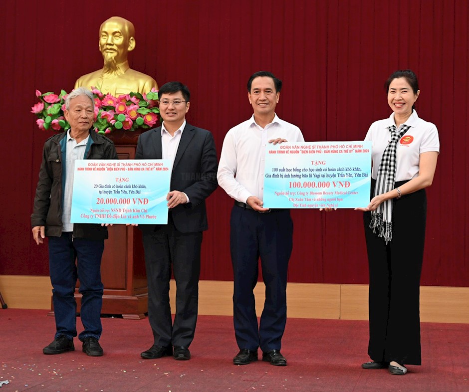 Đại diện lãnh đạo huyện Trấn Yên nhận bảng tượng trưng kinh phí hỗ trợ cho người dân, học sinh khó khăn trên địa bàn huyện với tổng kinh phí 120 triệu đồng