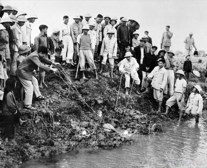 Chủ tịch Hồ Chí Minh đến thăm và tham gia tát nước chống hạn cùng nông dân xã Đại Thanh, Hà Đông (nay là Hà Nội), ngày 12/1/1958. (Ảnh: TTXVN)