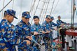 Sau khi tháo dây buộc buồm, các thành viên kíp tàu di chuyển xuống dưới mặt boong, vào vị trí cùng các học viên chuẩn bị dây kéo buồm.