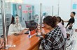 Cán bộ Trung tâm phục vụ hành chính công hướng dẫn người dân đến làm các thủ tục hành chính. (Ảnh: TTXVN)