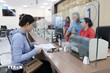 Cán bộ Trung tâm phục vụ hành chính công hướng dẫn người dân đến làm các thủ tục hành chính. (Ảnh: TTXVN)